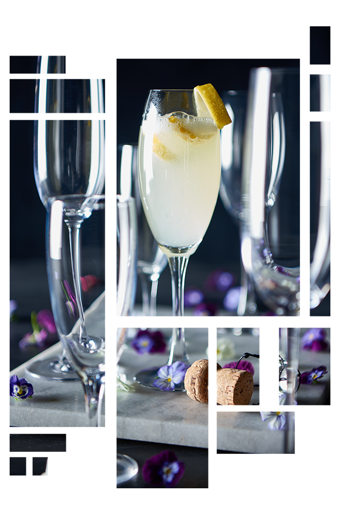 Mange champagneglas står, hvor et er fyldt med champagne og citron. Der ligger små lilla blomster rundt omkring, Cocktails